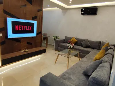 a living room with a couch and a tv at Apartment 5 minutes from Marrakech Airport in Marrakech