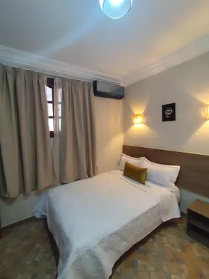 a bedroom with a white bed and a window at Apartment 5 minutes from Marrakech Airport in Marrakech