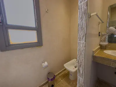 a bathroom with a sink and a toilet and a window at Riad Tonaroz Gold in Marrakech