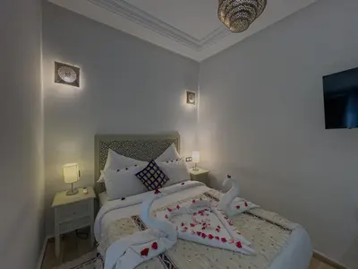 a bedroom with a bed with white sheets and pillows at Riad Tonaroz Gold in Marrakech