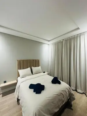 a bedroom with a large bed with two blue shirts on it at 3 bedroom apartment in Marrakech