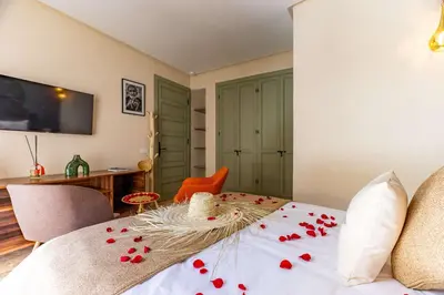 a bedroom with a bed with red rose petals on it at Riad 26 in Marrakech