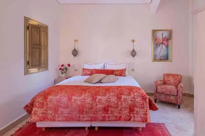 a bedroom with a red bed and a red chair at Riad Bayda in Marrakech