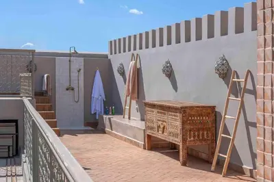 a balcony with a wooden chest and a wall at Riad Bayda in Marrakech