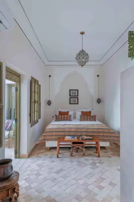 a bedroom with a large bed and two benches at Riad Bayda in Marrakech