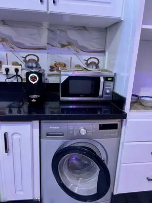 a kitchen with a washing machine and a microwave at Appartement spacieux de luxe familial in Marrakech