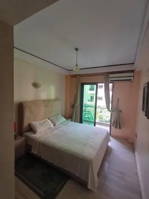 a bedroom with a bed and a large window at Résidence les amis 2 chambres appartement familial in Marrakech