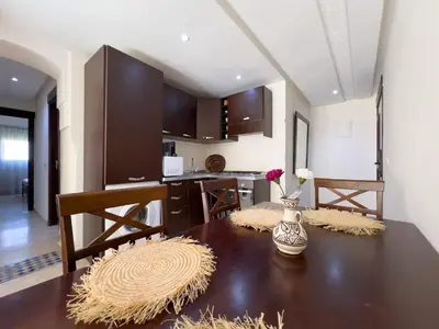 a kitchen with a wooden table with a vase of flowers on it at Stylish Stay downtown in Marrakech