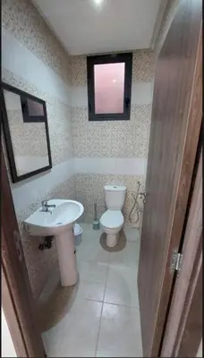 a bathroom with a sink and a toilet and a window at Kech Amal Apartment in Marrakech