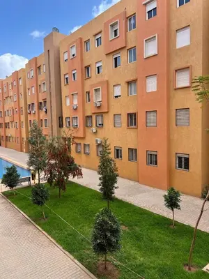 a large brick building with trees in front of it at Marrakech Luxe & confort Appartement in Marrakech