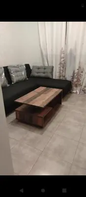 a black couch with a wooden coffee table in a living room at Appartement calme chez Nawal in Marrakech