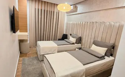 a hotel room with two beds and a television at Modern 2BR, Pool Access, Fast Wi-Fi in Marrakech
