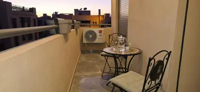 a balcony with a table and chairs on a balcony at Modern 2BR, Pool Access, Fast Wi-Fi in Marrakech