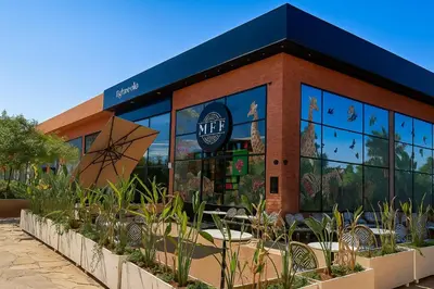 a building with a cafe with plants in front of it at Noria Golf - séjour chic et zen à Marrakech in Marrakech