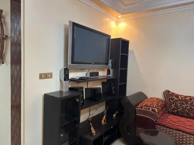 a living room with a television and a couch at Al acadimya in Marrakech