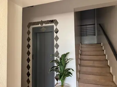 a hallway with stairs and a door with a plant at Al acadimya in Marrakech