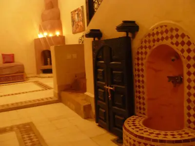 a room with a door and a chair in a room at Riad Marrakech - Piscine -Wifi- résidence qarya essyahia in Marrakech