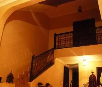 a living room with a staircase and a mirror at Riad Marrakech - Piscine -Wifi- résidence qarya essyahia in Marrakech