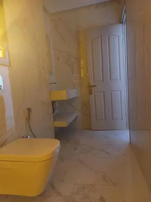 a bathroom with a yellow toilet and a door at Marrakech Riad in Marrakech