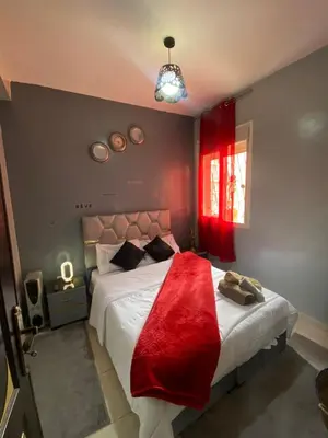 a bedroom with a bed with a red blanket on it at Marrakech Gateway in Oulad Akkou