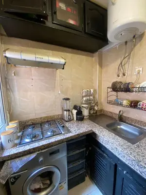 a kitchen with a stove and a washing machine at Marrakech Gateway in Oulad Akkou