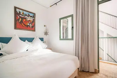 a bedroom with a white bed and a window at Riad Dar Rafaël in Marrakech