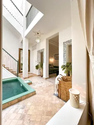 a swimming pool in a living room with a house at Riad Dar Rafaël in Marrakech