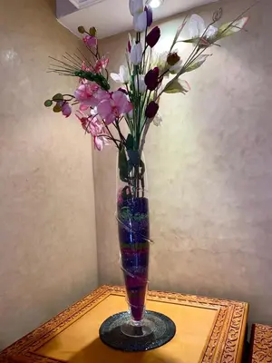 a vase with flowers in it on a table at Villa floor Espace ouvert in Marrakech