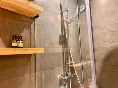 a shower with two bottles of alcohol sitting on a shelf at Quiet & Cosy Apartment in Central Gueliz in Marrakech
