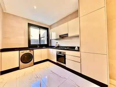 a kitchen with white cabinets and a washer and dryer at Quiet & Cosy Apartment in Central Gueliz in Marrakech