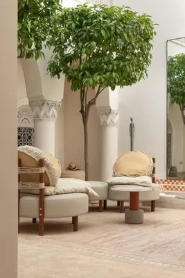 a room with two chairs and a tree in it at Riad Djannaat Exceptional private riad pool staff in Marrakech