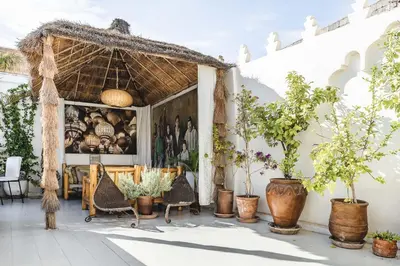 a patio with chairs and potted plants in front of a building at Riad Aguaviva in Marrakech