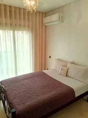a bedroom with a bed with a chandelier and a window at Appartement en plein centre in Marrakech