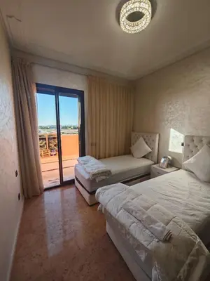 a hotel room with two beds and a large window at Ennaim in Marrakech