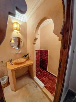 a bathroom with a sink and a shower with a mirror at Riad Tecla in Marrakech