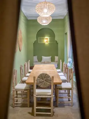 a dining room with a wooden table and chairs at Riad Tecla in Marrakech