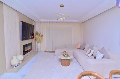 a living room with a white couch and a tv at Luxury apartment with jaccuzi in Marrakech