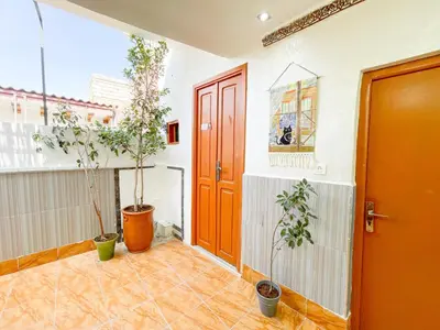 a hallway with two potted plants and a red door at Bubbly Hostel Marrakech in Marrakech