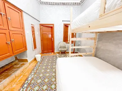 a bedroom with a bunk bed and a chair at Bubbly Hostel Marrakech in Marrakech