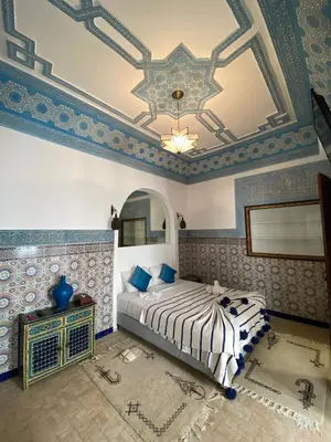 a bedroom with a bed and a ceiling with a mirror at Riad Alma Mouassine in Marrakech