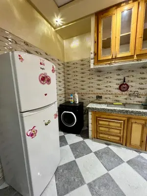 a kitchen with a white refrigerator and a checkered floor at Appartement spacieux marocain traditionnel familial in Marrakech