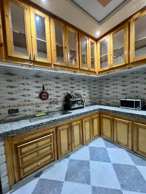 a kitchen with wooden cabinets and a tile floor at Appartement spacieux marocain traditionnel familial in Marrakech