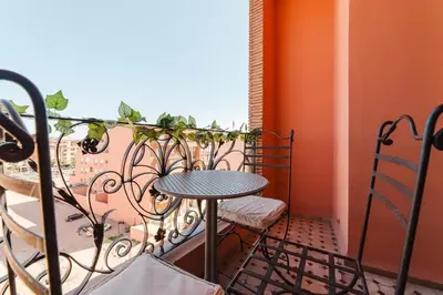 a balcony with a table and chairs and a window at Appartement Malika Gueliz in Marrakech