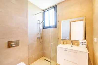 a bathroom with a shower and a sink and a mirror at New! Appt moderne avec terrasse et vue piscine in Marrakech