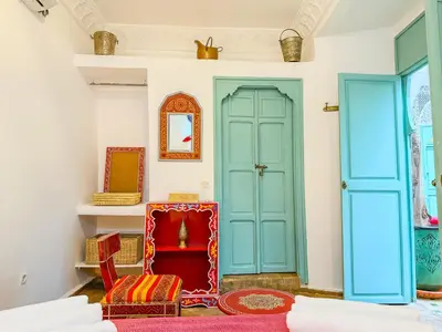 a room with blue doors and a red chair at Riad medina d'or in Marrakech