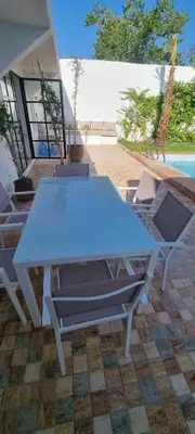 a blue table and chairs sitting next to a pool at VILLa PALMS KECH in Marrakech