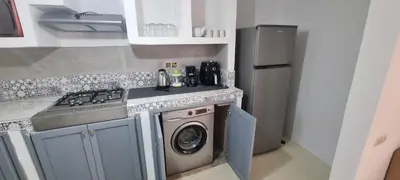 a kitchen with a stove and a washing machine at VILLa PALMS KECH in Marrakech
