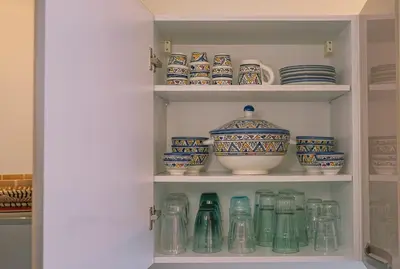 a cupboard filled with lots of dishes and vases at Appartement chaleureux agréable pour des vacances en famille in Marrakech
