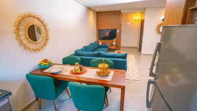 a living room with a table and a couch at Appartement chaleureux agréable pour des vacances en famille in Marrakech