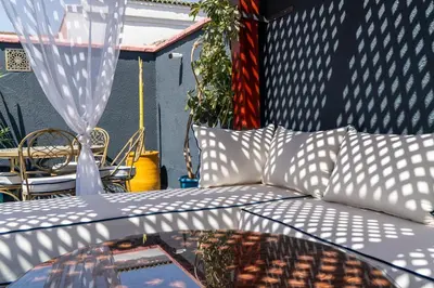 a white couch sitting on a patio with a table at Riad Serendip in Marrakech
